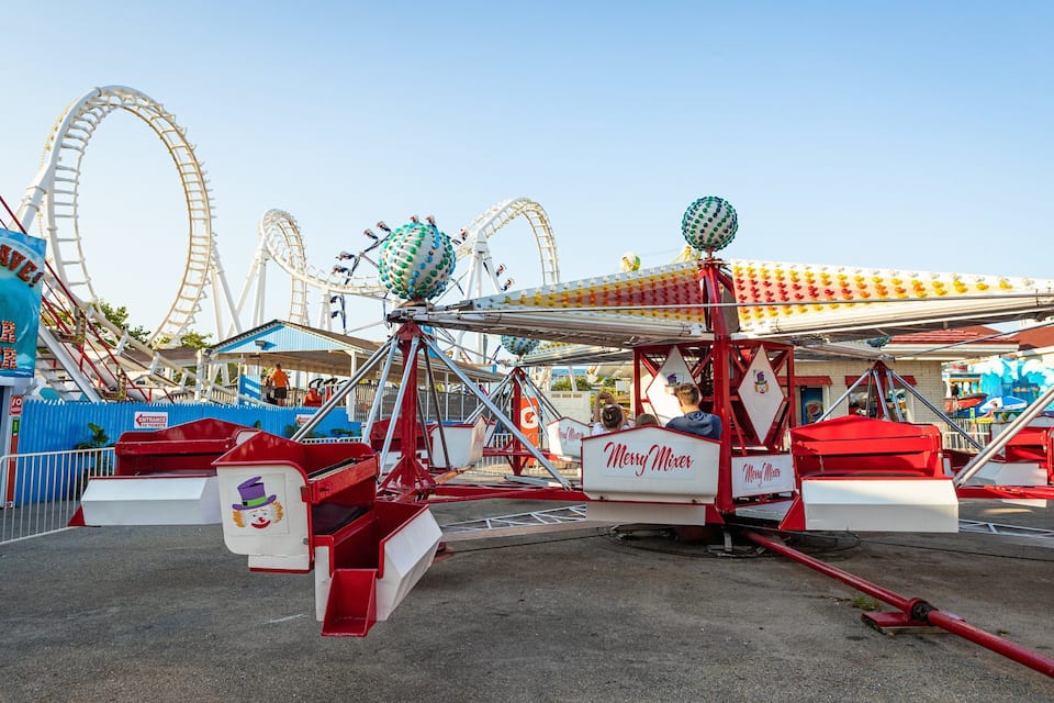 A roller coaster and a Ferris wheel at an amusement park.