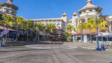 Resort com pátio central, palmeiras e um edifício grande com várias cúpulas e varandas.