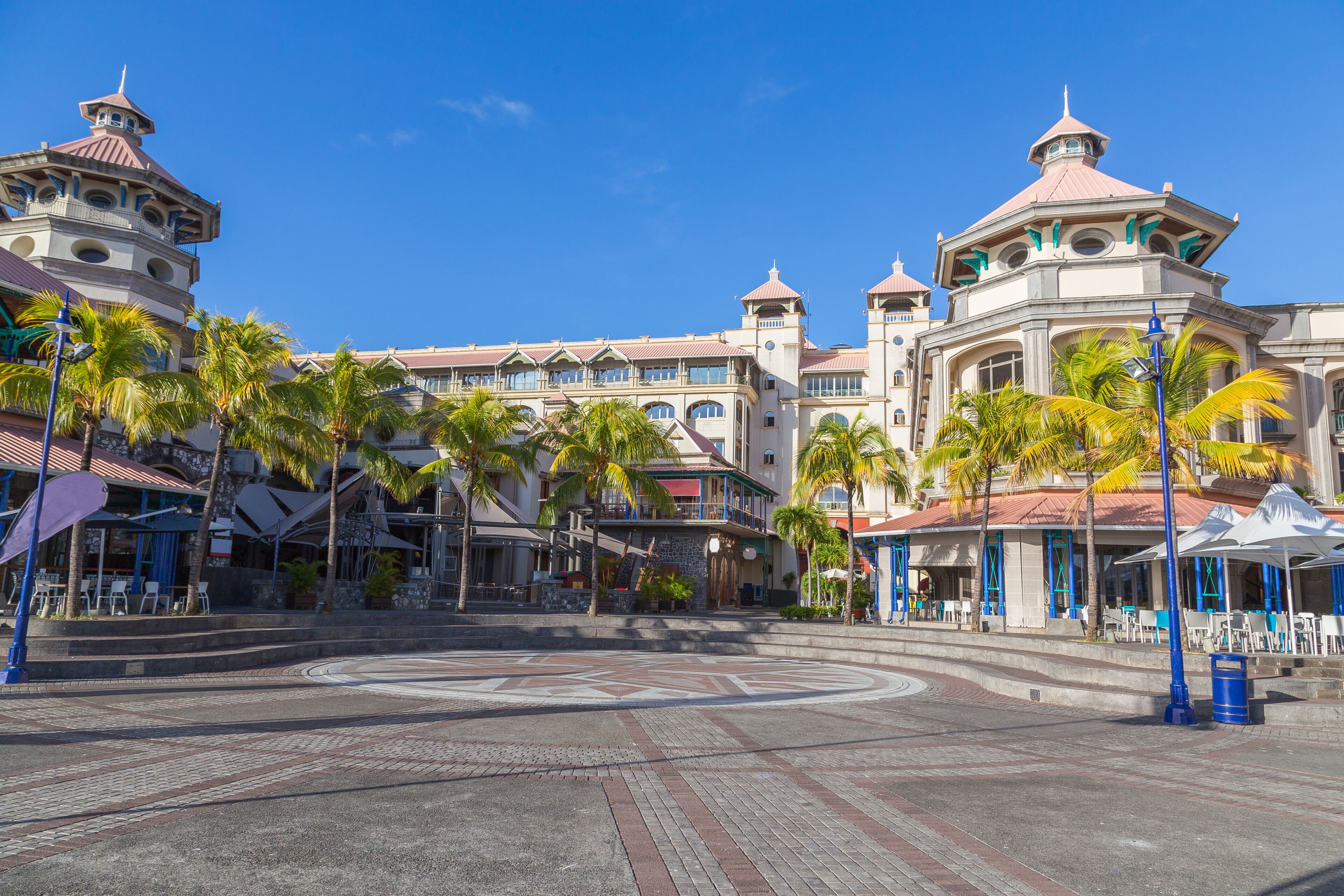 A resort with a central courtyard, palm trees, and a large building with multiple domes and balconies.