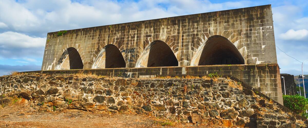 A large stone structure with multiple arched openings and a stone ramp leading up to it.