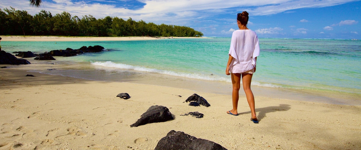 Ile aux Cerfs Beach mostrando vistas de una costa y una playa y también una mujer