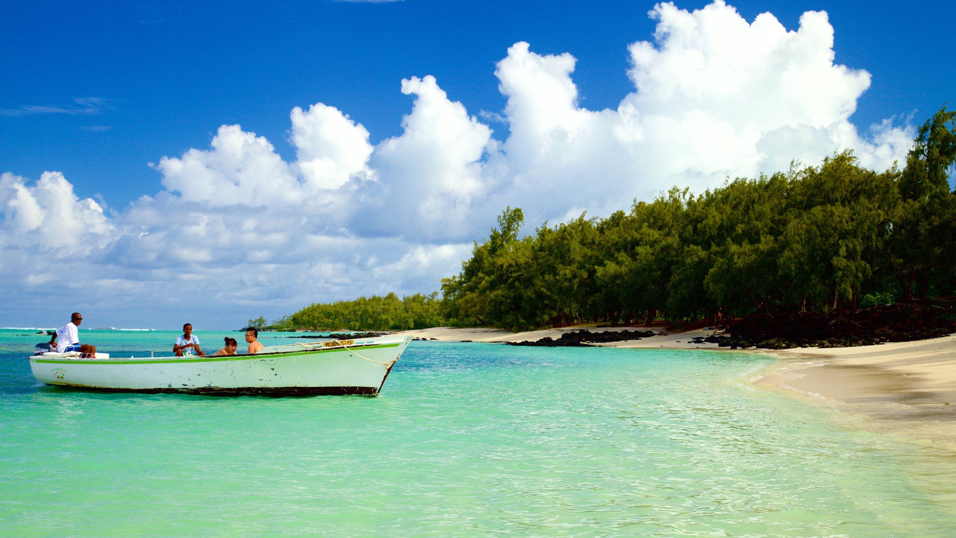 Ile aux Cerfs Beach mostrando una playa de arena y embarcaciones y también un grupo pequeño de personas