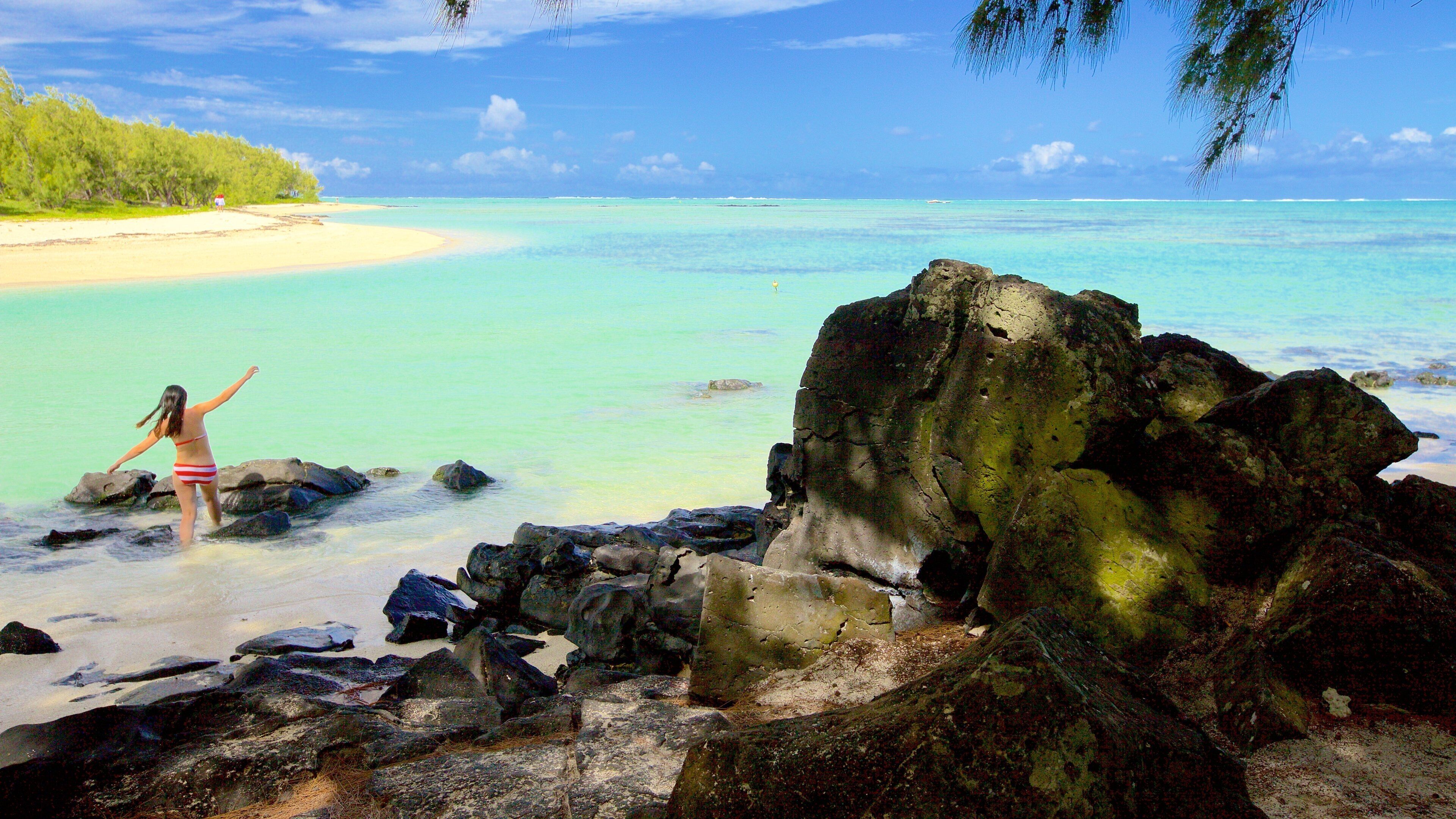 Ile aux Cerfs Beach featuring rocky coastline and general coastal views as well as an individual femail