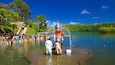 A large statue in a lake surrounded by people.