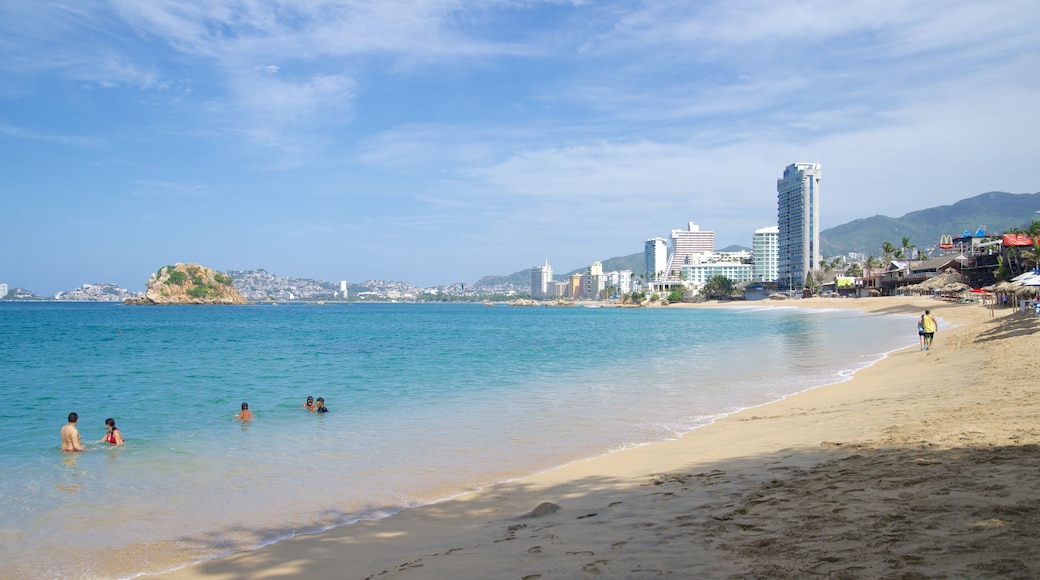 Condesa Beach which includes a coastal town and a sandy beach