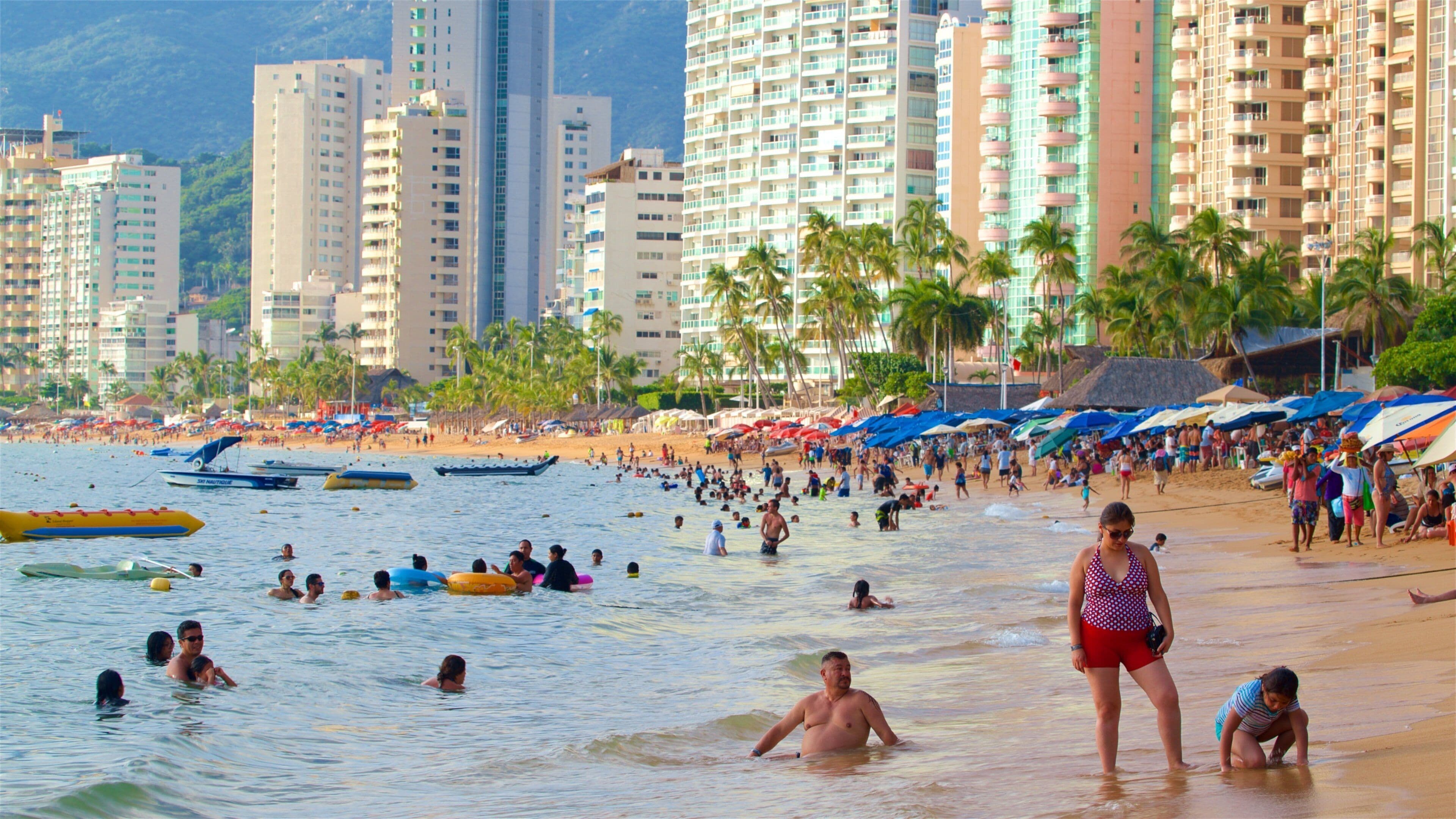 Playa Icacos ofreciendo una ciudad, una playa de arena y natación