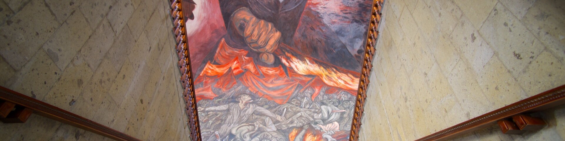 Um mural com a figura de alguém de braço levantado, um fundo flamejante e uma escadaria que leva a ele.