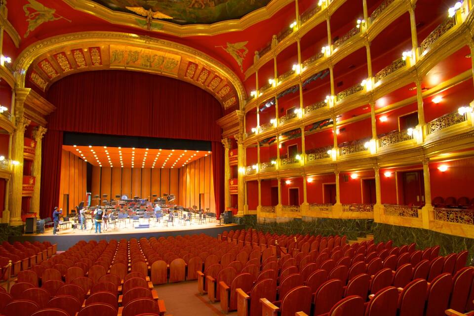 Un magnifique théâtre avec des sièges rouges, des balcons richement décorés et une scène.