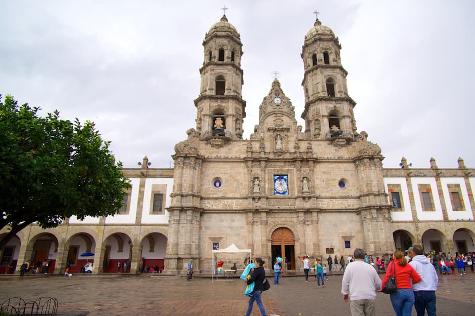 Una iglesia histórica con dos torres de campanas y un amplio acceso principal.