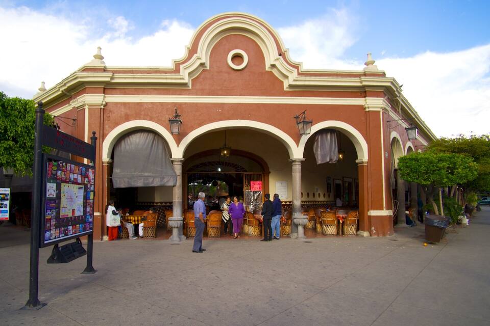 A historic building with arched entrances and a red facade.