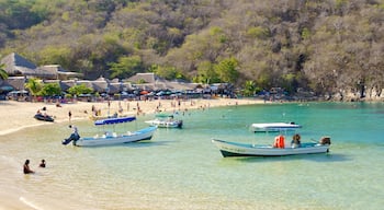 Playa La Entrega que incluye un hotel de lujo o resort, vista general a la costa y botes