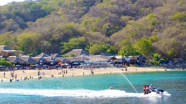 La Entrega Beach featuring jet skiing, a coastal town and a beach