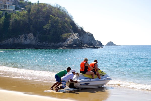 Zaachila Beach which includes general coastal views, a sandy beach and jet skiing