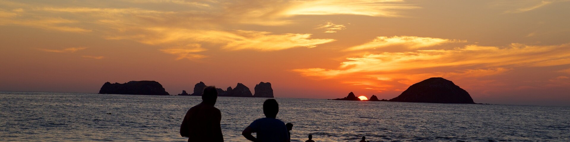 Playa de El Palmar que incluye un atardecer y vista general a la costa y también un gran grupo de personas