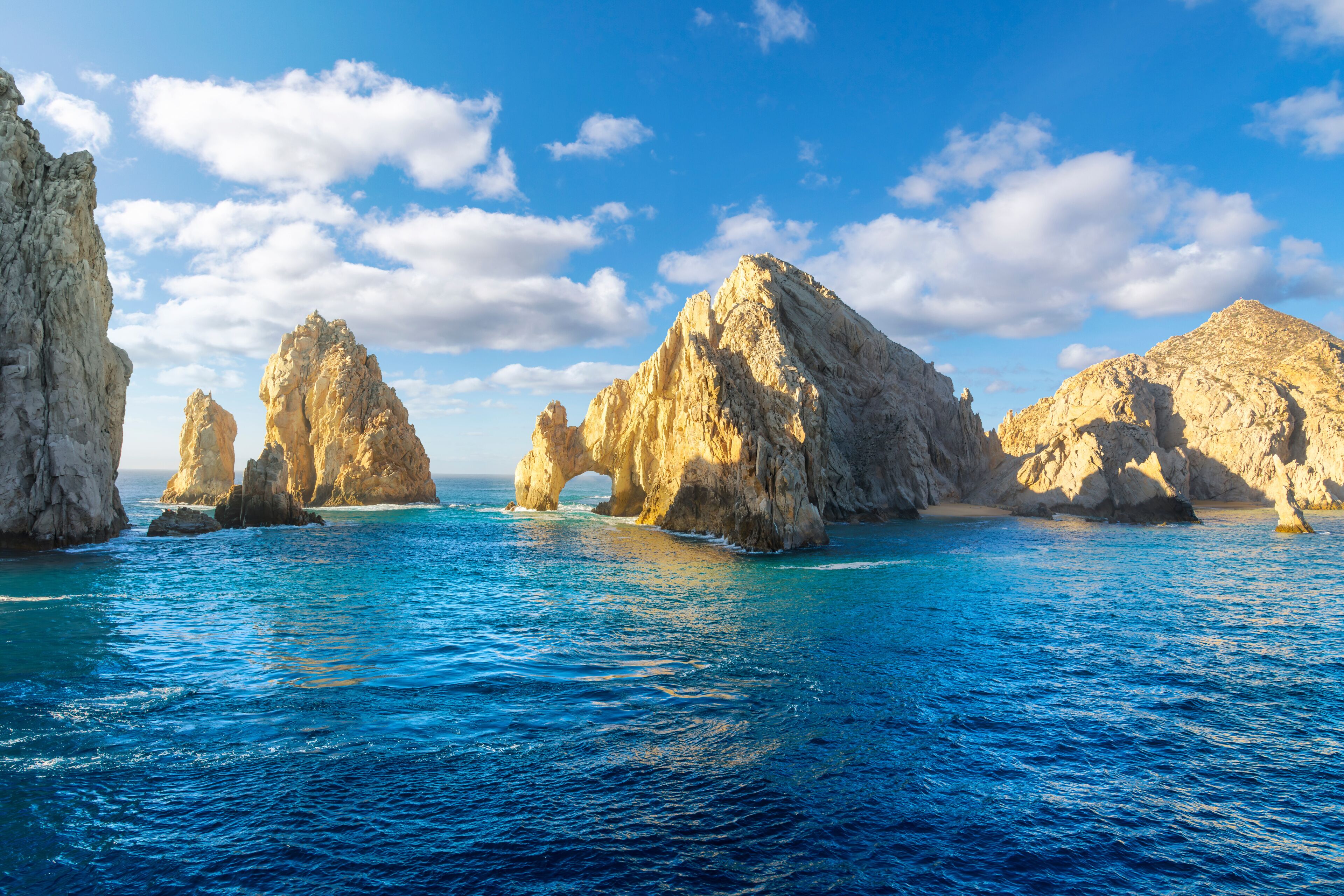 Sunlight highlights the famous El Arco Arch at the Land's End granite rock formations on the Baja Peninsula, at the Sea of Cortez, Cabo San Lucas, Mexico.	