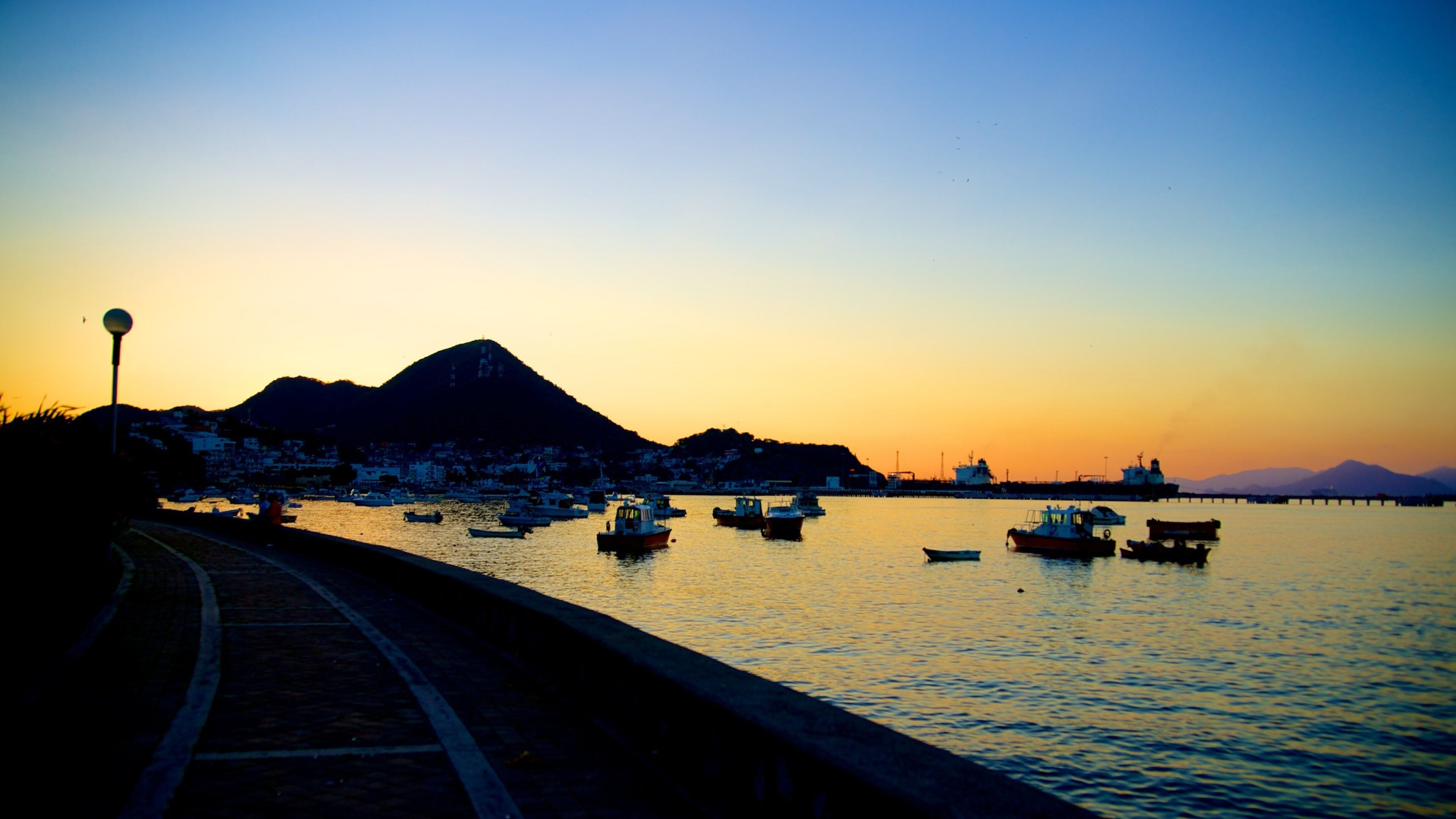 Playa San Pedrito que incluye un atardecer, vista general a la costa y una bahía o un puerto
