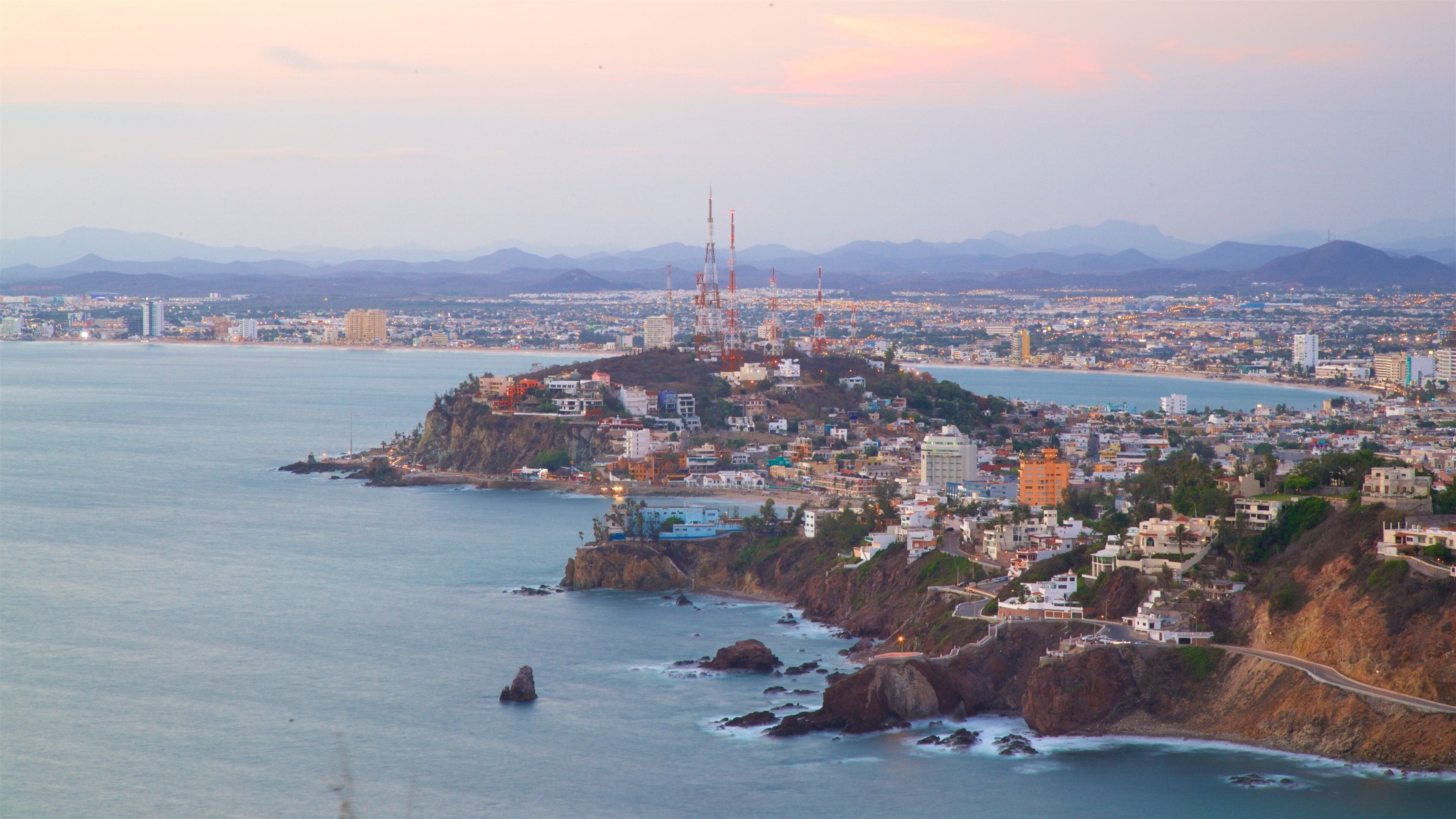 El Faro Lighthouse which includes a city, a sunset and general coastal views