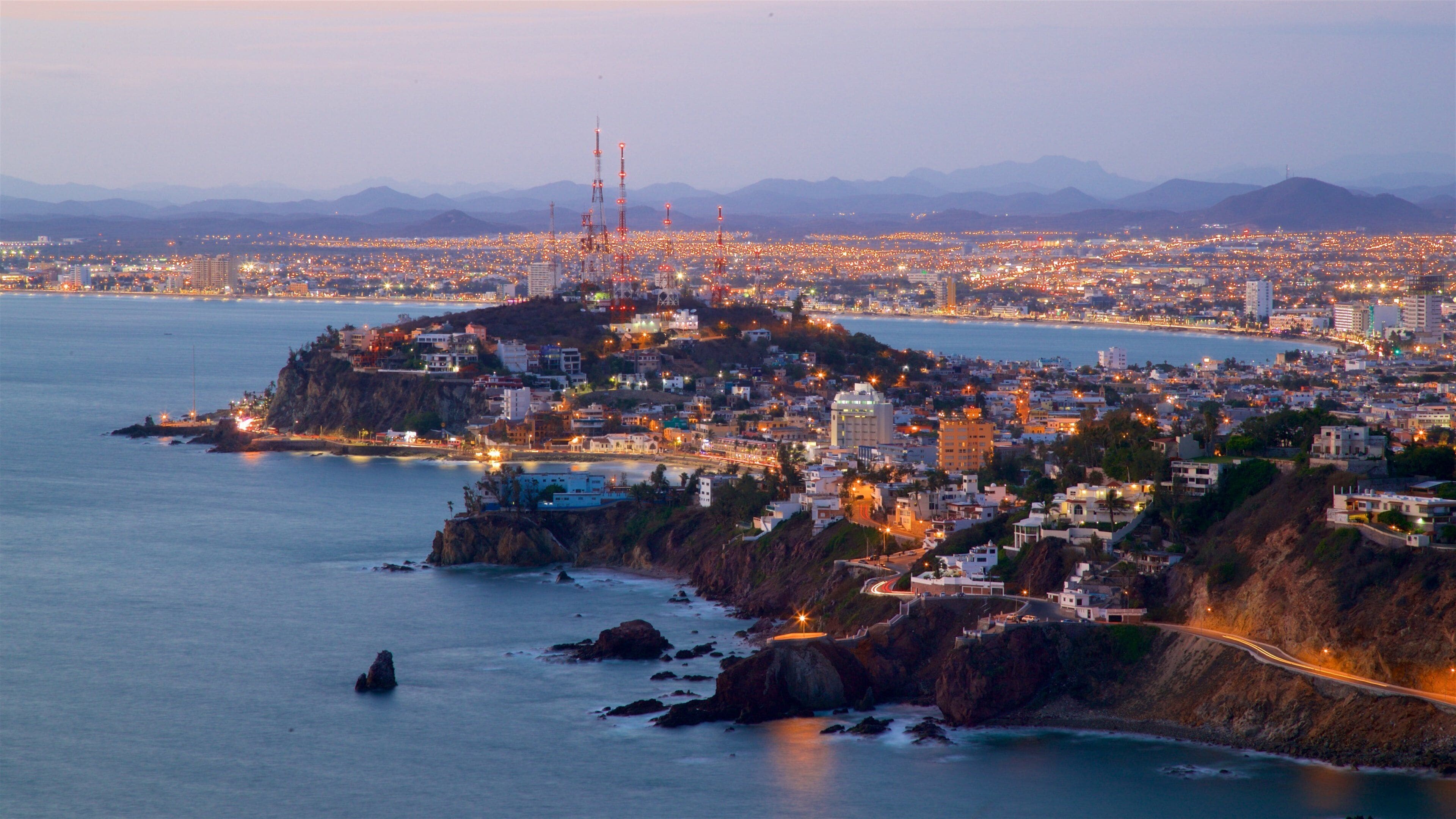 El Faro Lighthouse which includes night scenes, a city and general coastal views