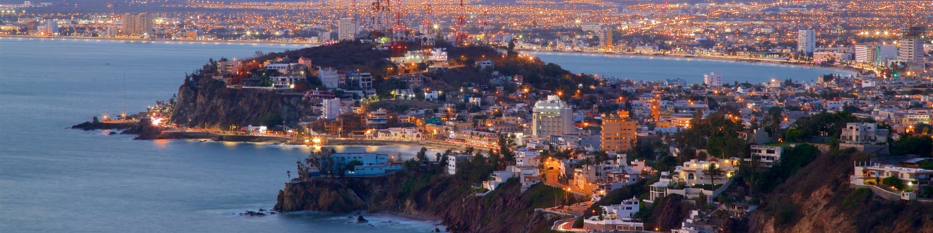 El Faro Lighthouse which includes night scenes, a city and general coastal views