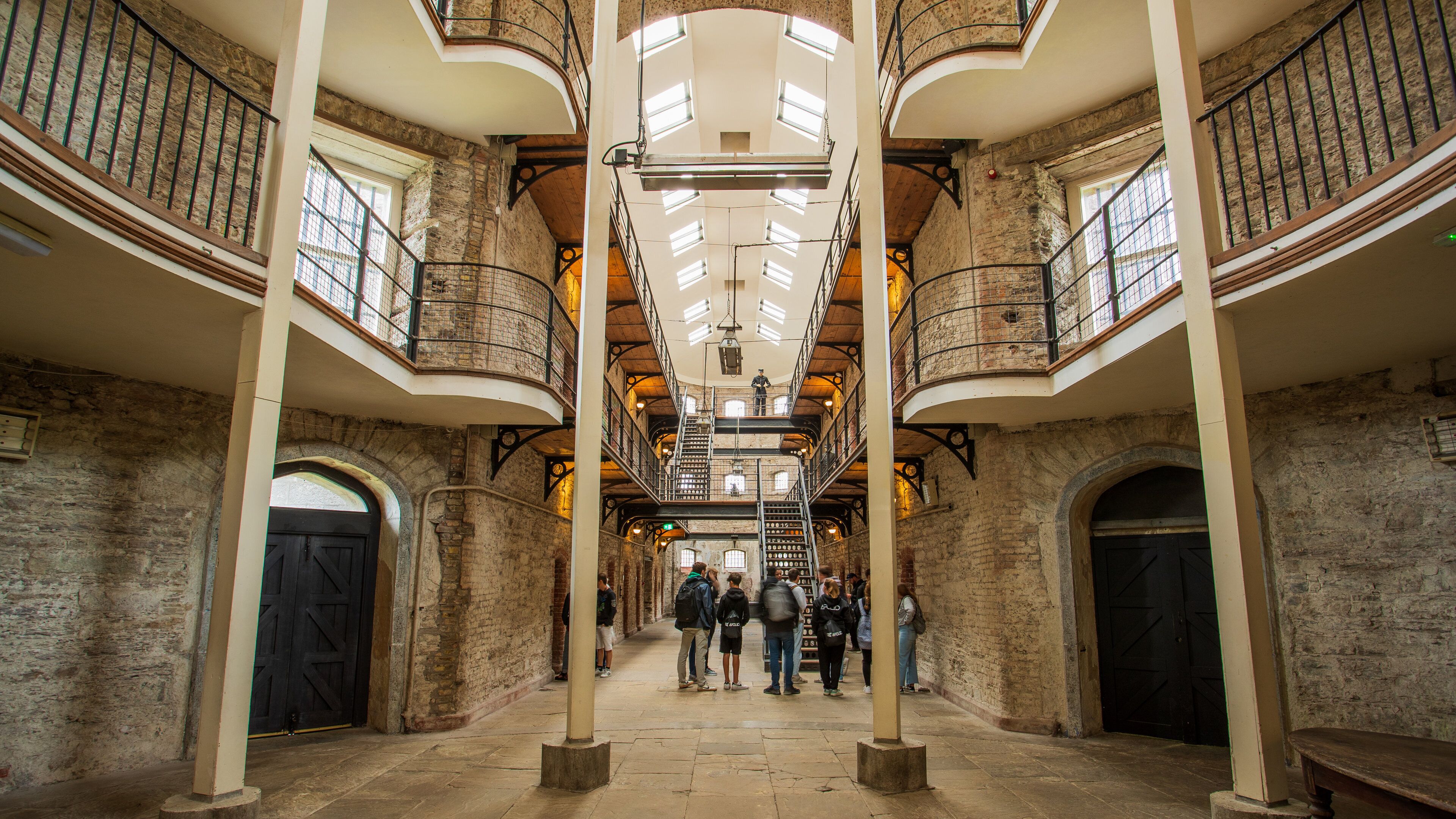 Cork City Gaol featuring interior views and heritage elements as well as a small group of people