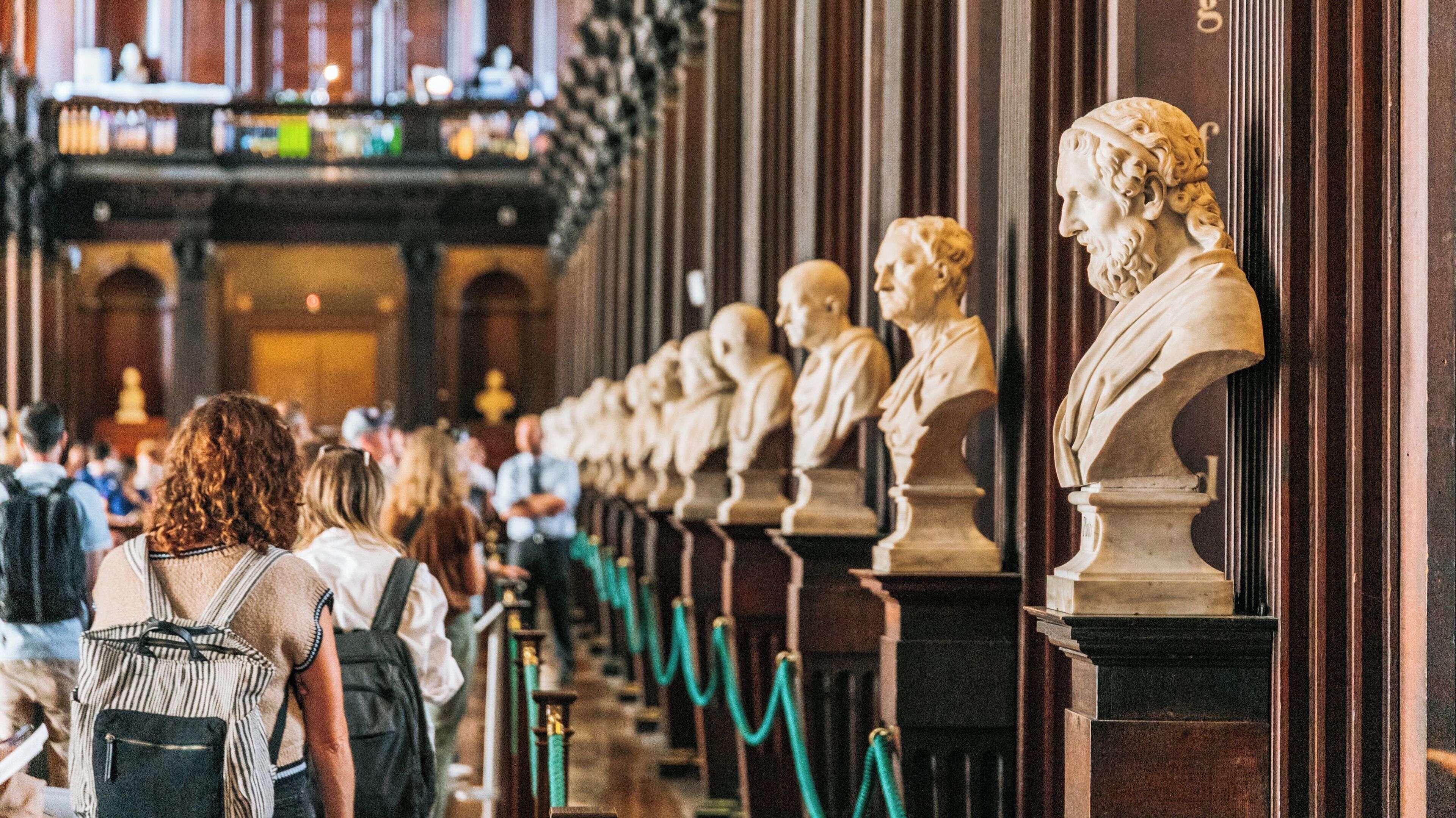 Visit to the Book of Kells exhibition in Temple Bar, Dublin, showcasing historical busts and captivating visitors immersed in culture