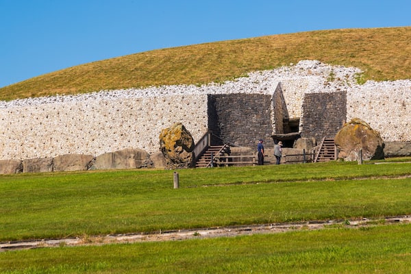A stone wall with a staircase leading up to a stone structure.
