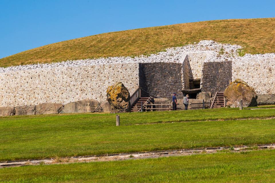 A stone wall with a staircase leading up to a stone structure.