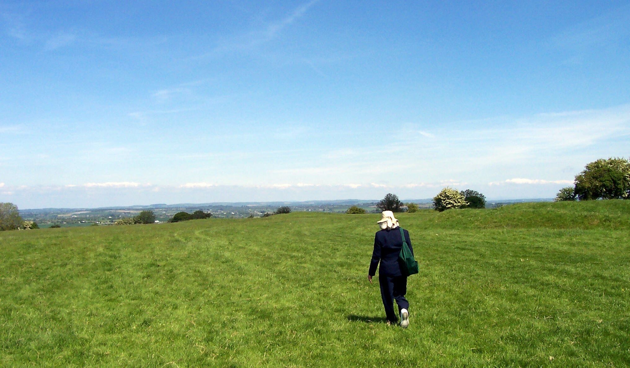 When I think of Ireland my mind returns to my Wife Cathy wandering the Hill of Tara.
This was probably one of the nicest days we had in Ireland.
We stopped in the little Village alongside the hill and had a "99" ( https://en.wikipedia.org/wiki/99_Flake ) in the Gift Shop then went into a Used Book Shop that had a Gentleman in a White Suit and a Panama Hat sitting outside of, he was the proprietor. We picked up a few items, among them was a paperback of the history of the Hill. When giving the items to the owner he looked at the little history book and asked if we would like him to autograph it, it turned out that he was the author. We had a great time chatting with him. An unforgettable day in May of 2004.