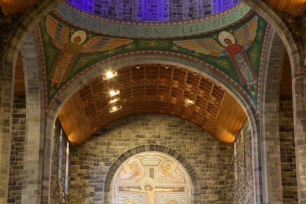 A church interior with a mosaic ceiling and a crucifix.