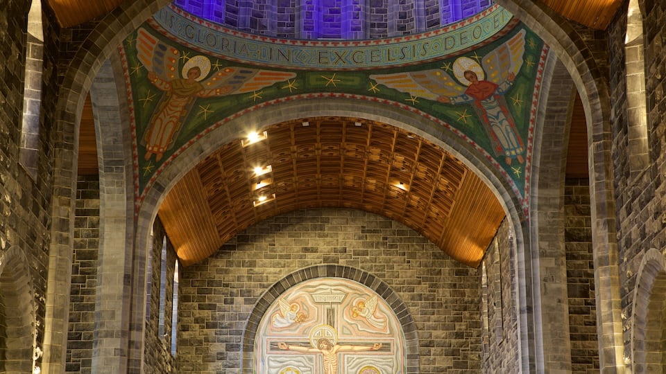 A church interior with a mosaic ceiling and a crucifix.