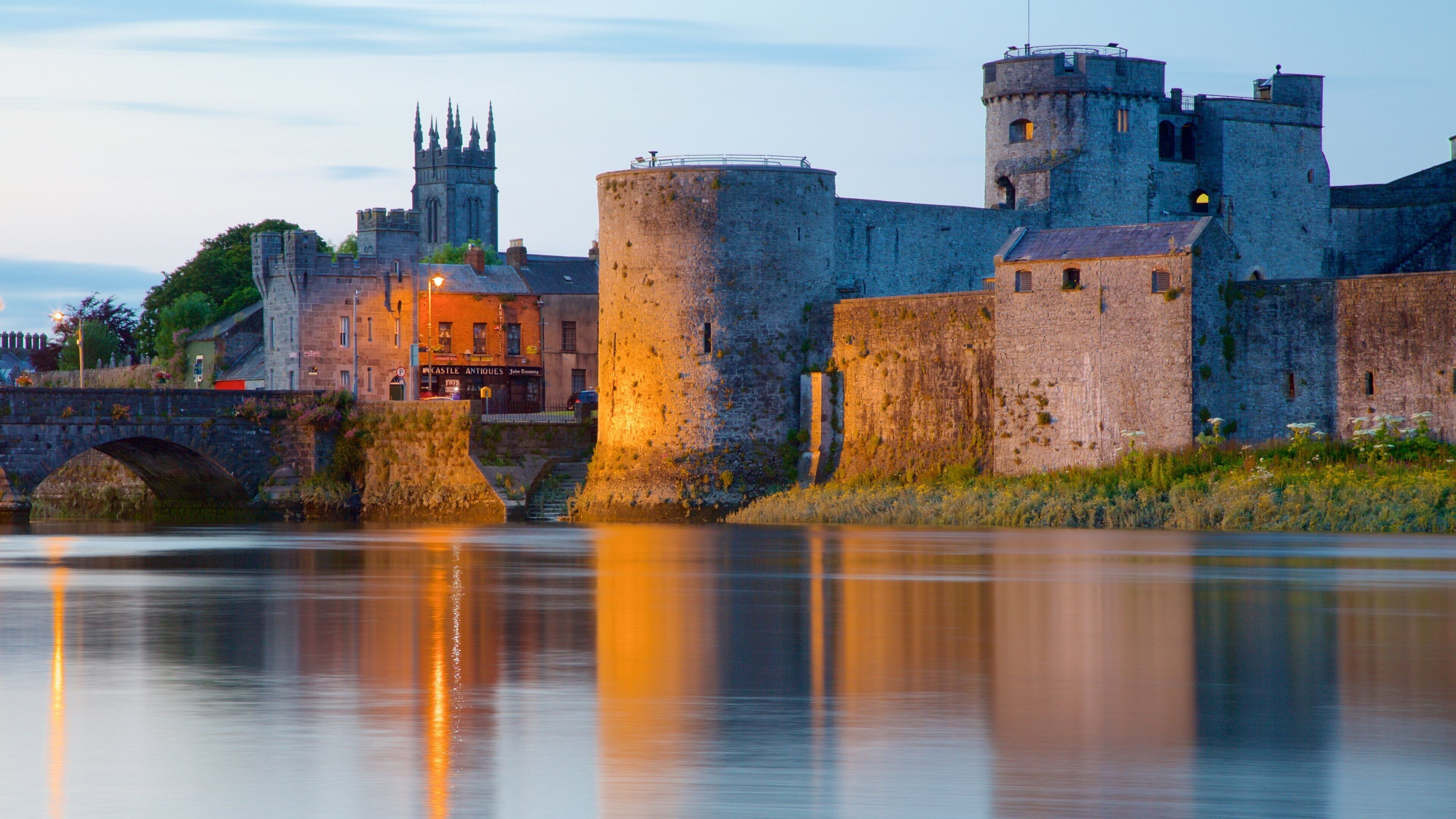 A historic castle with multiple towers and a bridge over a river.