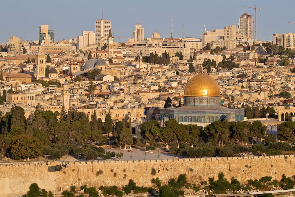 The Dome of the Rock in Jerusalem, surrounded by historic buildings and the Old City walls.
