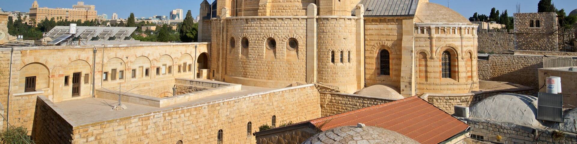 A historic stone building with multiple domes and towers.