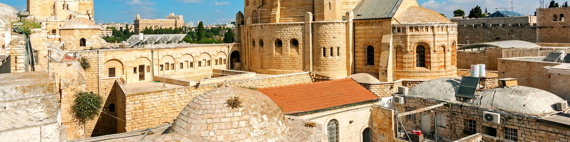 A historic stone building with a prominent tower and dome, surrounded by other ancient structures.