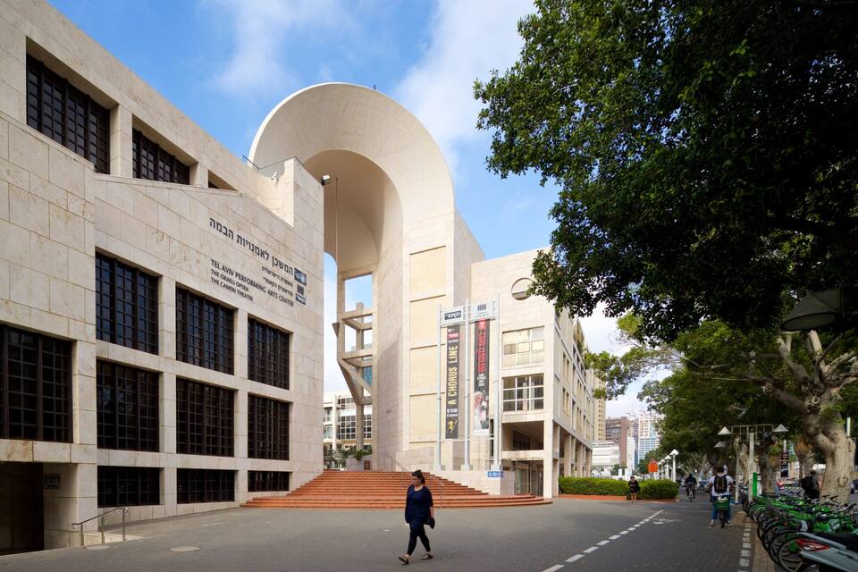 A modern building with a large arched entrance and multiple windows.