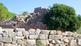 A stone wall with a tree on top.