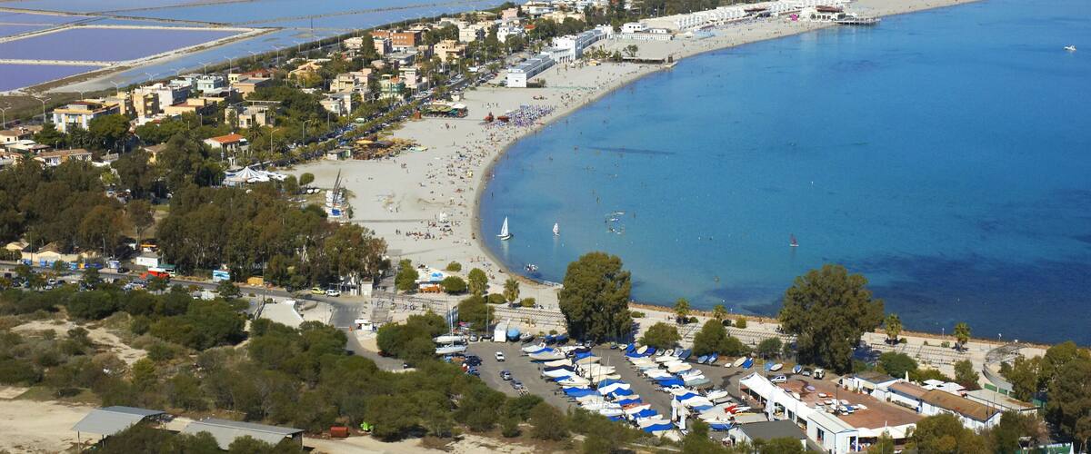 A coastal town with a beach, boats, and a marina.