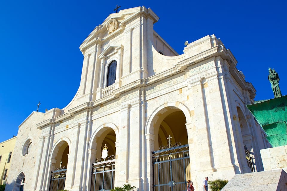 Uma igreja histórica com uma torre de sino e entradas em arco.
