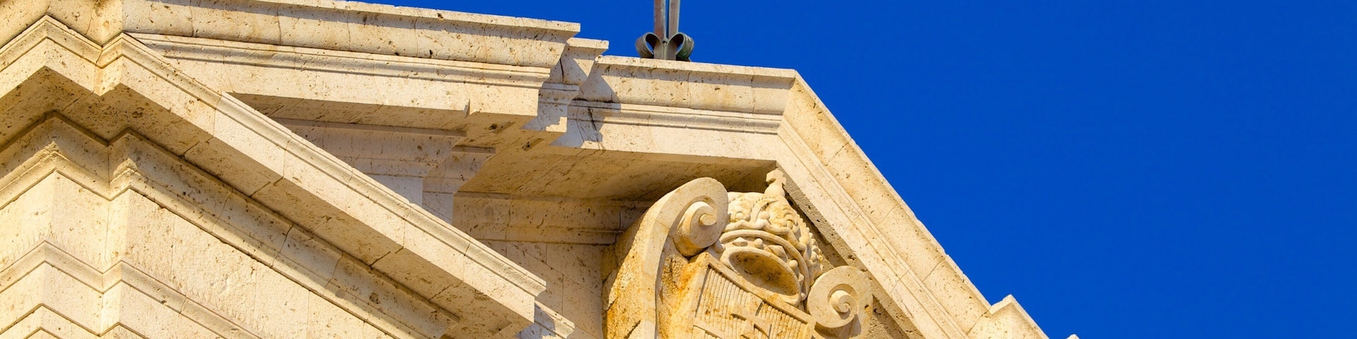 Un bâtiment orné d’une croix et d’un emblème représentant un lion.