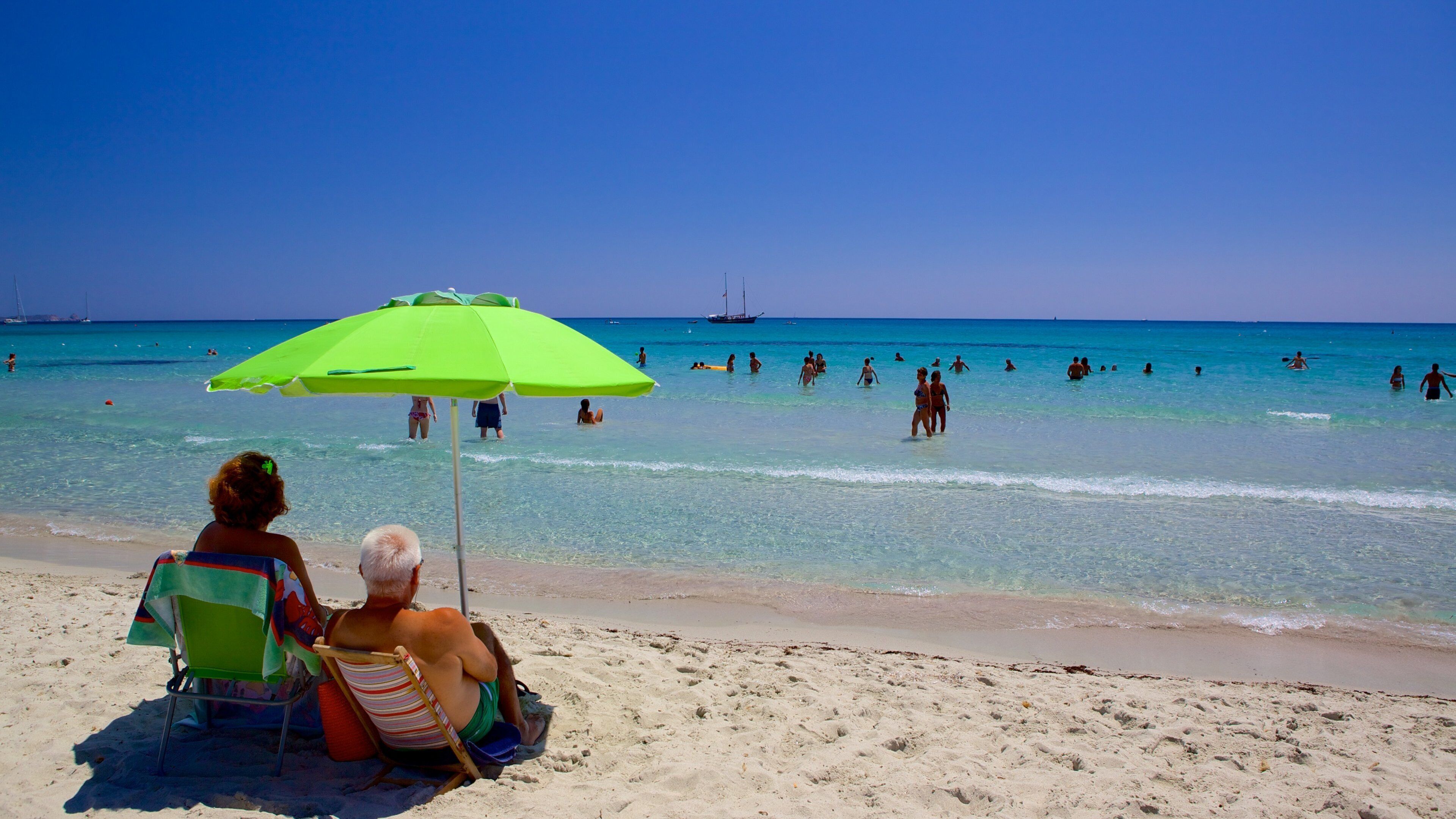 Simius Beach which includes swimming and a beach as well as a large group of people