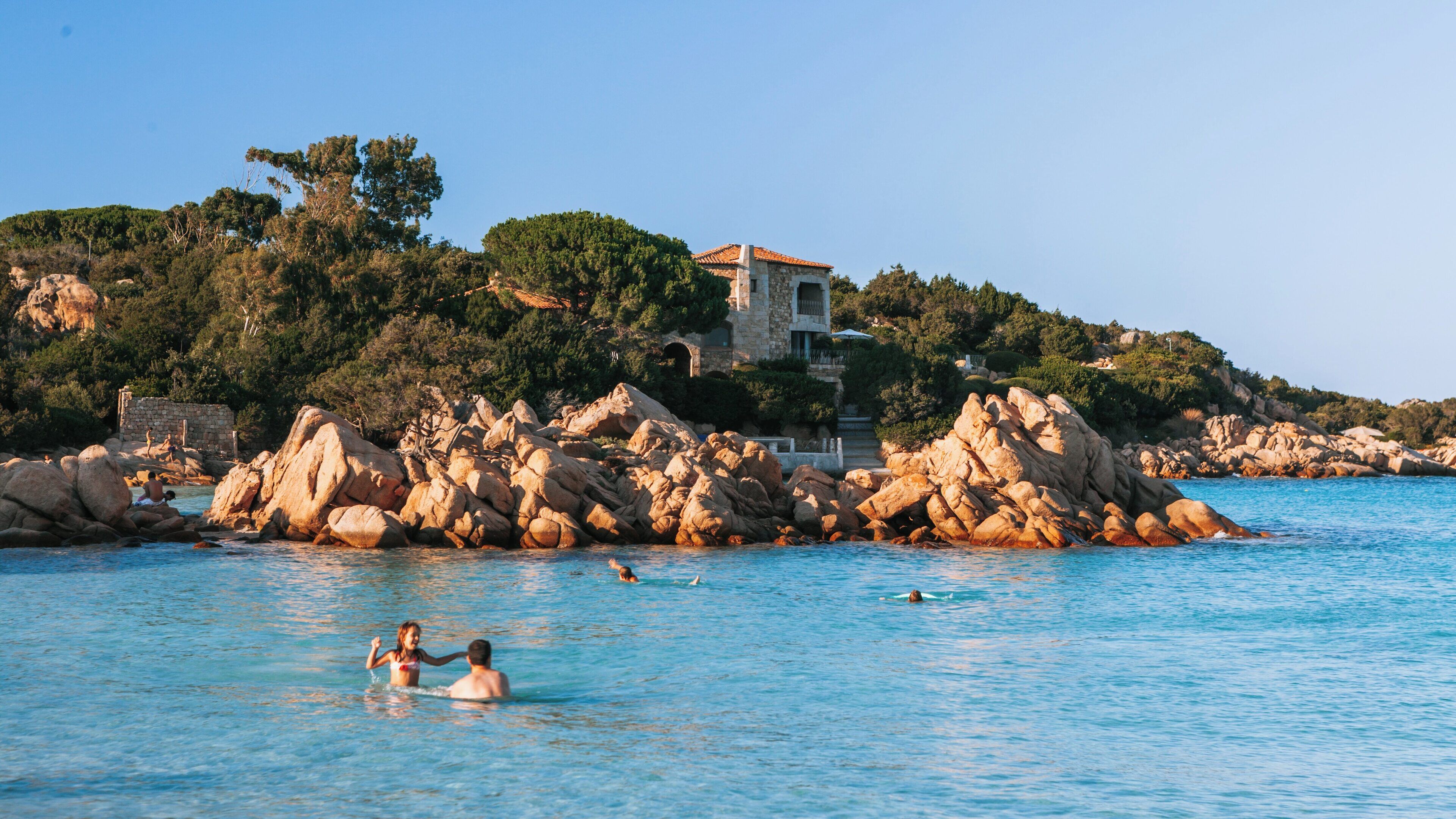 Enjoying the clear waters of Capriccioli Beach in Arzachena, Sardinia under the warm sun of a summer day