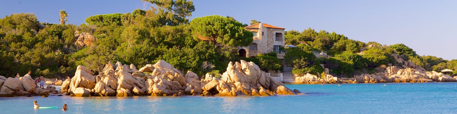 Capriccioli Beach showing swimming, rocky coastline and landscape views