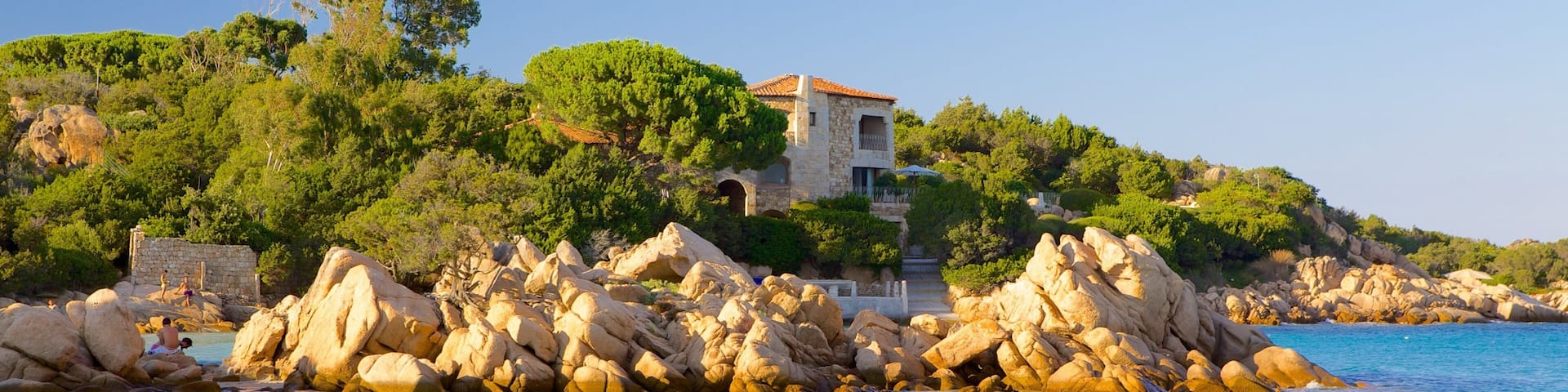Capriccioli Beach which includes a coastal town, swimming and landscape views