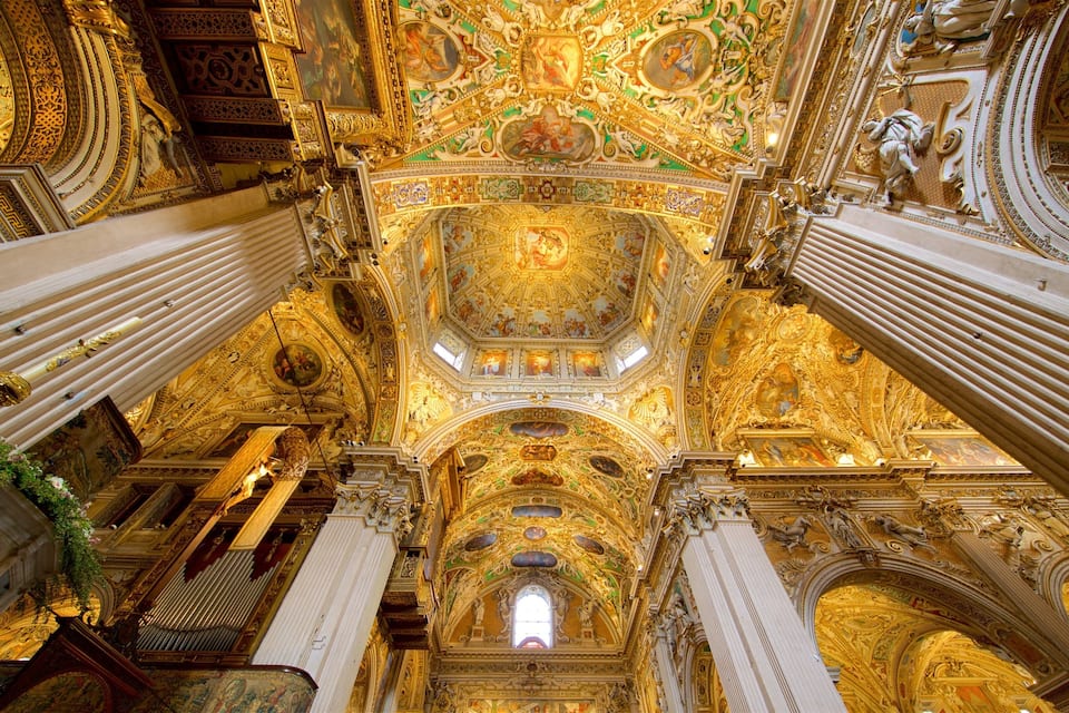An ornate interior with golden decorations, columns, and a detailed ceiling.