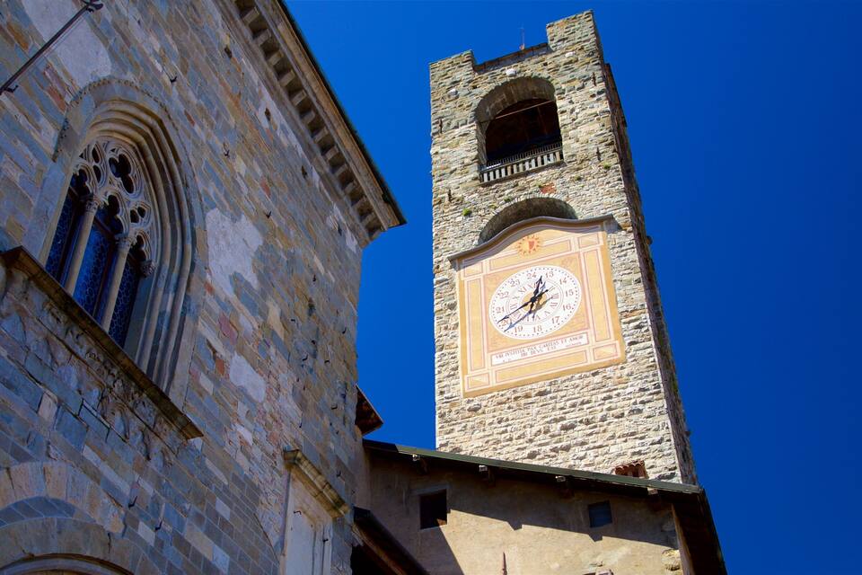 A historic stone tower with a clock and arched windows.