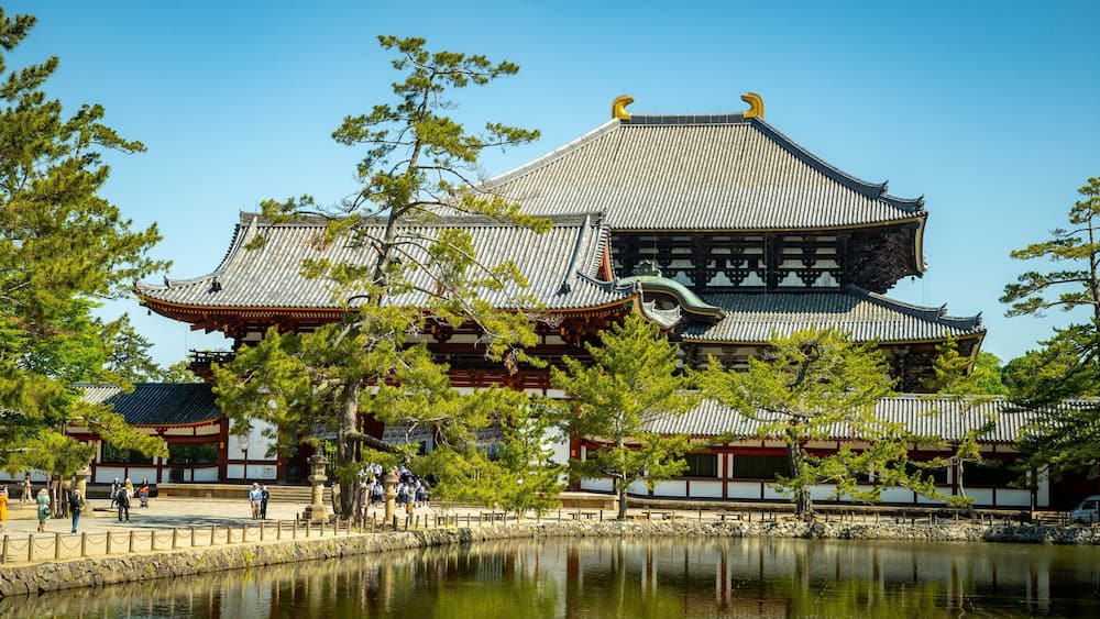 Todaiji Temple which includes a lake or waterhole, a temple or place of worship and heritage elements