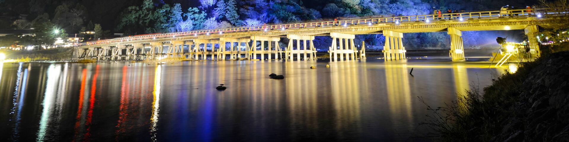 Togetsu Bridge reflecting in the Katsura River at night during the December illumination festival in the Arashiyama area of Kyoto