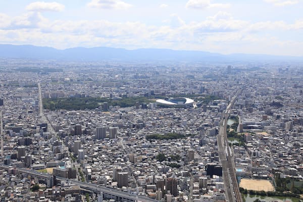 Un paysage urbain densément peuplé, avec un stade imposant et une rivière qui le traverse.