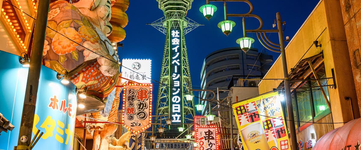 Tsutenkaku Tower which includes night scenes, signage and a city