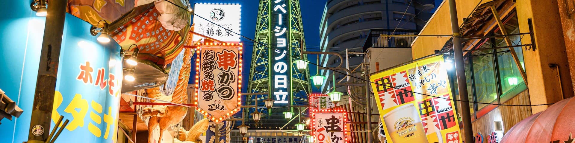 Tsutenkaku Tower which includes night scenes, signage and a city